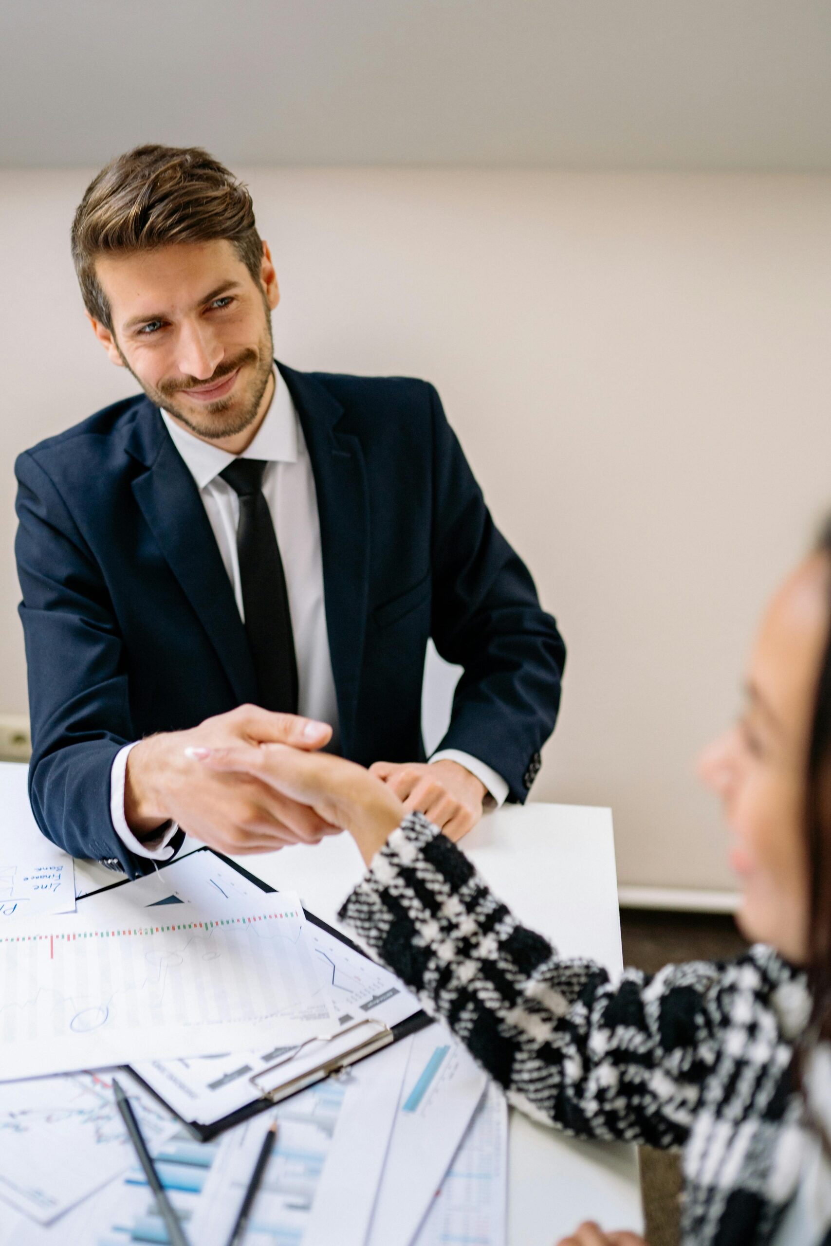 Professional businessmen shaking hands in an office environment, focused on teamwork and agreement.